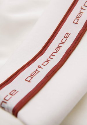 Weißer Stoff mit einem bordeauxrot-weißen gestreiften Band, das das Wort "Performance" im wiederholenden Text zeigt. Glatte Textur, minimalistisches Design.