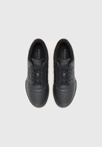 Sorte lærresneakers med perforert tå, snøring, myk innvendig polstring, og subtil merking på siden og tungen.
