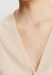 Helles rosa Cardigan mit V-Ausschnitt, aus weichem Stoff gefertigt und mit einer einzelnen Knopfverschluss vorne.