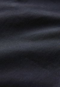 Tmavomodrá tkanina s jemnou ryhou textúrou, predvádzajúca mäkký, hladký povrch a konzistentnú farbu po celom. 