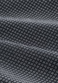 Schwarzer Stoff mit einem geometrischen weißen Muster aus kleinen Quadraten und Kreuzen, mit glatter Textur, das sanft fällt.