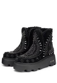 Stivaletti alla caviglia in suede nero con borchie in argento e cuciture decorative, dotati di una suola con platfrom e un upper testurizzato.