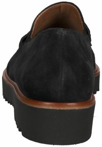 Chaussure en daim noir avec une texture lisse, un dos arrondi et un bord en cuir brun. Présente une épaisse semelle en caoutchouc noir avec des détails de traction.