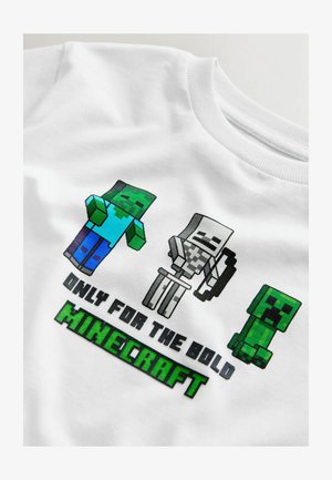 T-shirt blanc avec des personnages pixelisés de Minecraft : un zombie avec une chemise bleue, un squelette avec un arc, et un creeper vert, avec l'inscription « UNIQUEMENT POUR LES AUDACIEUX ».