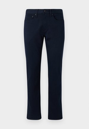 Pantaloni din denim bleumarin, cu croială slim, având un design clasic cu cinci buzunare și accente subtile de cusătură. Textură netedă și fără decorațiuni.