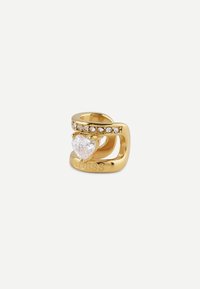 Anello in tonalità oro con una pietra chiara a forma di cuore e una fila di piccole pietre chiare. "GUESS" è inciso sulla fascia.