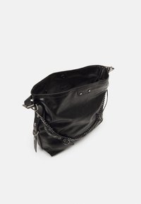 Geantă din piele neagră cu o finisare texturată, având o curea din lanț și accesorii metalice. Deschidere superioară cu închidere prin buton și detaliu cu etichetă în interior.