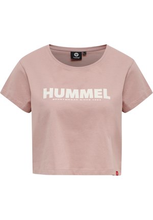 Jasnoróżowy krótki t-shirt z krótkimi rękawami i białym napisem "HUMMEL SPORTSWEAR SINCE 1923" na środku przodu.