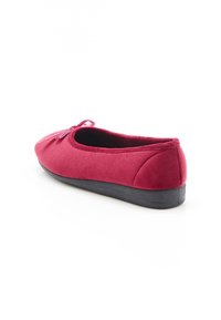 Scarpa piatta bordeaux realizzata in tessuto morbido, con punta arrotondata, parte superiore testurizzata e dettaglio a fiocco. Suola in gomma nera con lieve altezza.