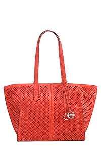 Sac fourre-tout perforé rouge avec deux longues poignées, doté d'un fond solide et d'accents en métal. Motif découpé au laser en détail sur l'ensemble.