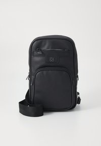 Borsa a spalla in pelle nera con finitura testurizzata, dotata di una tasca frontale con zip, dettaglio del logo e tracolla regolabile. Design compatto.