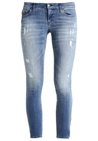 Jeans de denim azul ajustados con ligeras zonas desgastadas y áreas desvaídas, que presentan bolsillos frontales y cierre de botón.