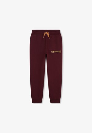 Pantalons de survêtement bordeaux avec une taille élastique et un cordon de serrage, ornés d'un logo doré "TIMBERLAND" sur la cuisse et avec des chevilles à poignets.