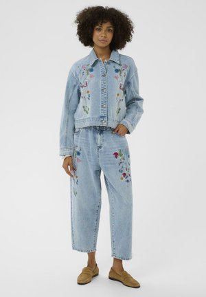 Šviesiai mėlynas džinsinis švarkelis ir laisvo silueto kelnės su įvairių spalvų gėlių siuvinėjimu. Yra sagos ir kišenės. Minkšta, tekstūruota medžiaga.