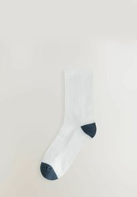 Calzino di cotone bianco a manica corta con texture a coste e accenti di colore blu scuro nel tallone e nella punta. Vestibilità standard, costruzione della punta senza cuciture.