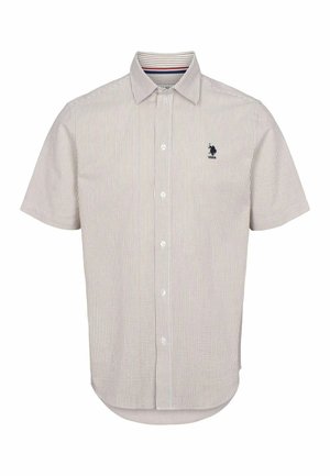 Lühikeste varrukatega nööbiga särk helesuhkruses, millel on õhukesed vertikaalsed triibud. Omab avarat kraed ja sinist logo rindkerel.