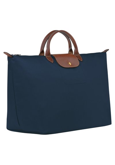 Navy blue fabric tote bag with brown leather handles and accents. Features a structured shape and a front pocket with a flap closure.