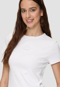 Biały t-shirt z krótkim rękawem o ryglowym wzorze, z haftowanym graficznym motywem słońca na piersi. Prosty okrągły dekolt i dopasowany krój.
