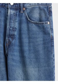 Jean en denim bleu clair avec une coupe classique, cinq poches, ferrures en cuivre et une texture subtilement délavée.