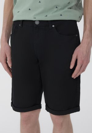 Pantaloni corti neri in cotone con orlo arrotolato, dotati di tasche frontali e chiusura a bottone. Tessuto morbido e vestibilità su misura.