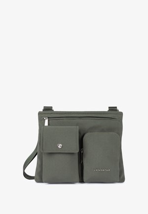 Borsa a tracolla verde in tessuto con finitura testurizzata, dotata di due tasche esterne e hardware in argento. Il marchio "LANCASTER" è impresso su di essa.
