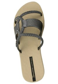 Sandali flat neri e scintillanti con un design a fascia intrecciata, dotati di una suola beige imbottita e di un logo prominente sulla soletta.