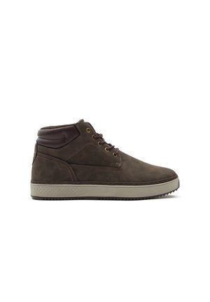 Zapato casual marrón de caña alta con cuello acolchado, panel lateral texturizado, cordones delanteros y suela gruesa de color gris claro sobre fondo blanco.