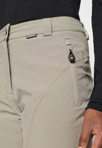 Svetlo sivi zunanji hlače z zadrgo na stranski žep, gladka tekstura in diskretni šivi, zasnovane za funkcionalnost in udobje.