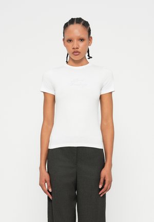 T-shirt bianco fitted in cotone morbido con maniche corte e scollatura rotonda, caratterizzato da un sottile ricamo "Mixed Feelings" sul petto.