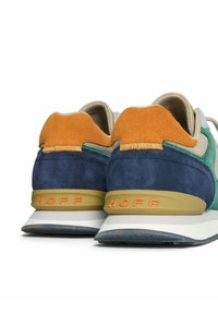 Zapatillas HOFF multicolores con materiales de ante y textil, forma redondeada, suelas acolchadas y un logotipo destacado en el talón.