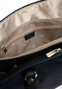 Borsa in pelle nera con fodera in tessuto beige, dotata di tasca con zip, etichetta con logo e motivo a diamante all'interno.