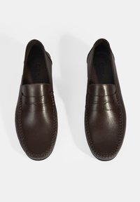 Bruine leren instapschoenen met een gladde afwerking, decoratieve stiksels langs de zijkanten en een lichte glans, met een gevormde bovenkant met een subtiel ontwerp.