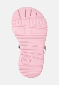 Pink rubber sandal sole with textured grip and branding. Features grooves and circular patterns for traction. Smooth finish overall.