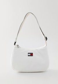 White Tommy Jeans shoulder bag with adjustable strap and zipper closure, featuring the brand's red, white, and blue logo patch on front.