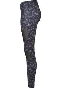 Mustat legginssit, joissa on kuvioitu kokonaisuus, jossa on paisley-motiiveja. Sivuilla on verkko-osiota lisäämään hengittävyyttä ja tyyliä.