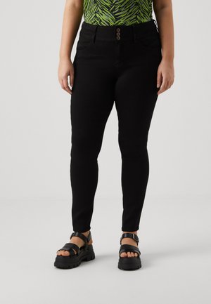 Sorte skinny jeans med høy midje, med en lukking med tre knapper og sidelommer. Kombinert med sorte plattform sandaler.