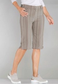 Grijze gestreepte capri-broeken van lichtgewicht stof met zijzakken en splitten aan de onderkant, gecombineerd met grijze instapschoenen.