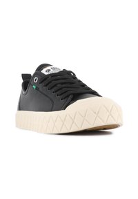 Sneaker nera con tomaia in pelle testurizzata, suola in gomma e punta in gomma di colore crema. Presenta lacci neri e un accento verde.