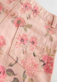 Virágmintás rózsaszín szövet zöld részletekkel. Hátsó zseb lekerekített formával és virágos grafikával. Sima textúrájú.