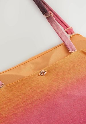 Sac tote dégradé avec des nuances d'orange à rose, texture de tissu lisse et accent logo métallique près du haut. Anses bicolores.