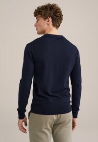 Pulover tricotat de culoare albastru marin, cu guler, mâneci lungi și manșete și tiv cu model. Textură netedă, design ajustat.