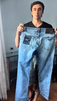 Ανοιχτού μπλε τζιν παντελόνι κρατημένο κατακόρυφα, με μεσαία γραμμή στη μέση, ίσια πόδια και ετικέτα της μάρκας στην πίσω τσέπη.