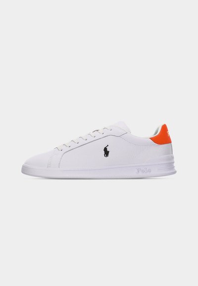 Sneaker bianca bassa con logo Polo nero sul lato e linguetta sul tallone arancione brillante, mostrata su uno sfondo bianco semplice.