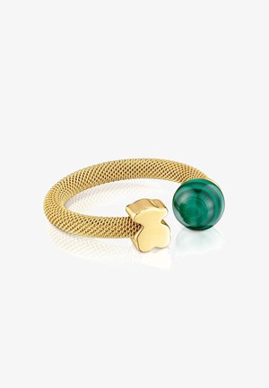 Bracelet en maille dorée avec un charme poli en forme d'ours à une extrémité et une pierre ronde en malachite verte à l'autre extrémité.