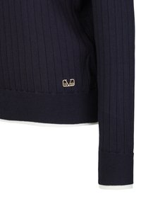 Marineblauer Rippstrickpullover mit einem weißen Saum und Bündchen. Verfügt über ein kleines goldfarbenes Logo mit "1969". Weiche Textur, taillierte Passform.