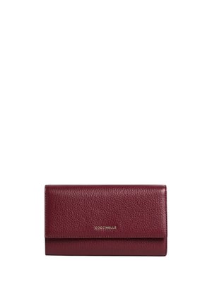 Portafoglio in pelle bordeaux con superficie texturizzata, chiusura a pattina e logo dorato sul davanti, forma rettangolare con linee pulite.