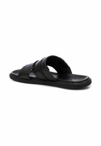 Chanclas negras con diseño de tiras cruzadas. Fabricadas en material sintético suave con parte superior texturizada y suela acolchada para mayor comodidad.