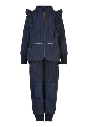 Ensemble deux pièces matelassé bleu marine avec des accents de renflement sur les épaules, un col haut et des poignets élastiques. Présente un passepoil argenté contrastant sur la veste.