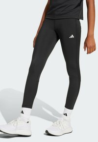 Leggings de sport noirs avec une coupe ajustée, dotés d'un logo adidas blanc sur la cuisse et de coutures plates pour le confort.