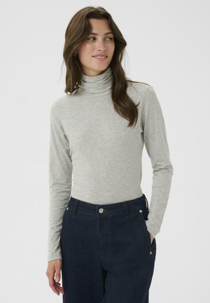 Top de cuello alto gris hecho de tejido suave, diseño ajustado con mangas largas. Combinado con pantalones de mezclilla oscuros, que muestran una textura lisa.